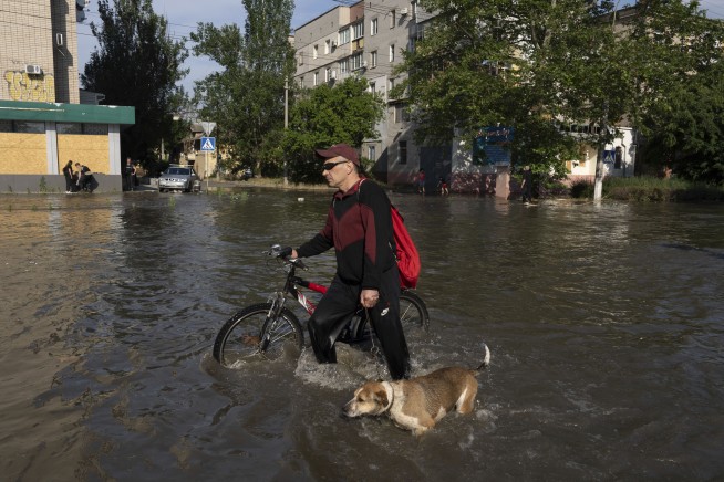 Ukrainians make desperate escape from floods after dam collapse as shelling echoes overhead