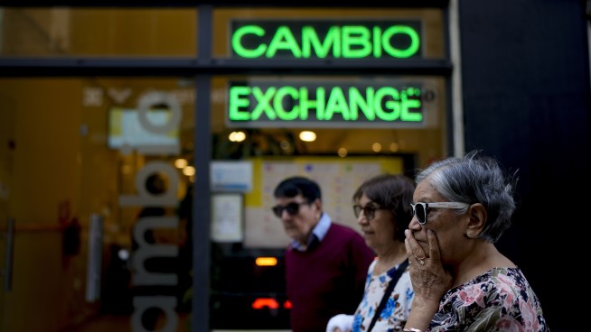 Argentina sharply devalues its currency and cuts subsidies as part of shock economic measures