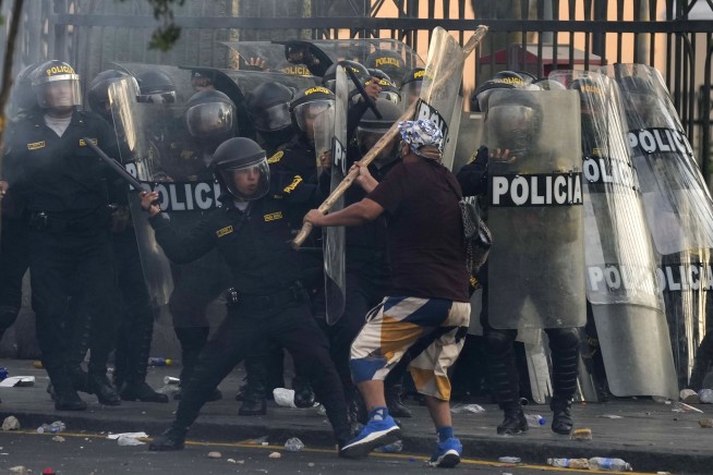 Peru's protest 'deactivators' run toward tear gas to stop it