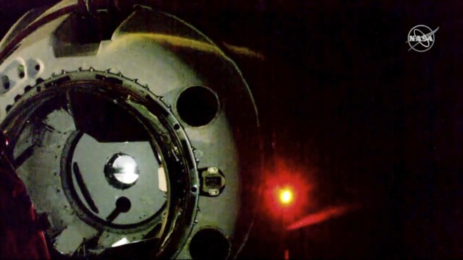 US-built capsule with a dummy aboard docks at space station