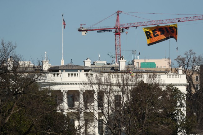 Protesters hoist 'RESIST' banner from crane near White House