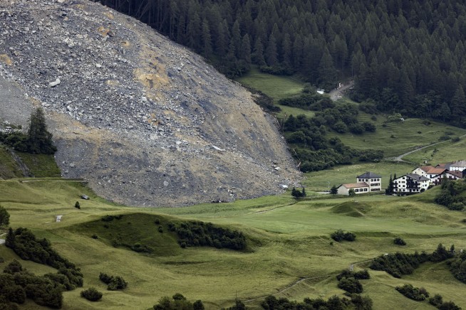 Mass of rock slides down Swiss mountainside above evacuated village, narrowly missing settlement
