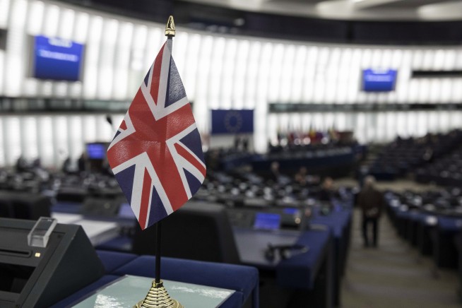 The Latest: UK's May wins vote to keep job, Brexit chaos