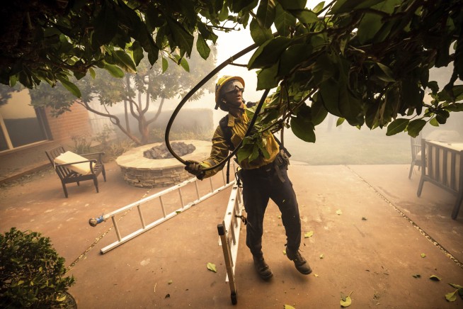 Thousands ordered to evacuate as powerful wind-fed wildfire burns homes in Southern California