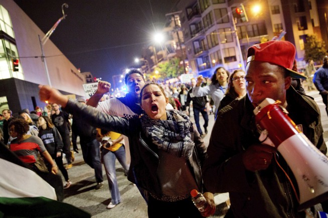 Anti-Trump protesters march amid tear gas, flash grenades