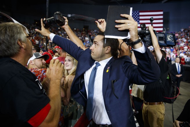 Trump volunteer blocks news photographer's shot of protester