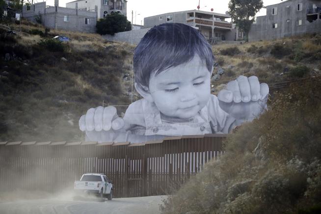 Yes, That's a Giant Toddler Peering Over Border Wall
