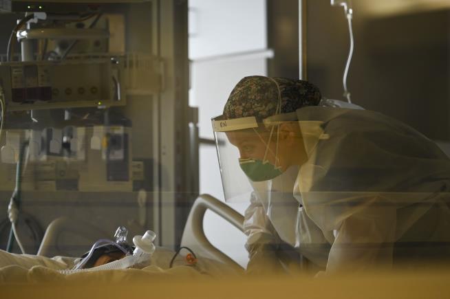 In this Dec. 7, 2020, file photo, a critical care nurse with North Memorial Health Hospital leans down to speak to a COVID-19 patient under their care in Robbinsdale, Minn. (Aaron Lavinsky/Star Tribune via AP)