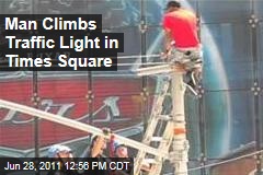 New York City Times Square: Man Climbs Up Traffic Pole